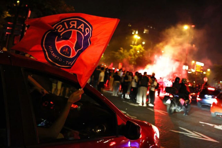 Soccer Football - Champions League - Final - Paris St Germain fans gather in Paris - Paris, France - May 31, 2025 Paris St Germain fans wave a flag out of a car window after winning the Champions League.