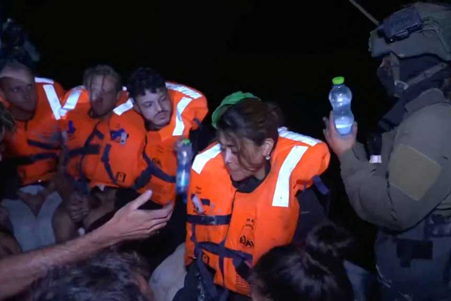 An Israeli solider passes water to those onboard the Gaza-bound British-flagged yacht "Madleen" after Israeli forces boarded the charity vessel as it attempted to reach the Gaza Strip in defiance of an Israeli naval blockade, in this screengrab from video released on June 9, 2025 — Israel Foreign Ministry via X/Handout via REUTERS