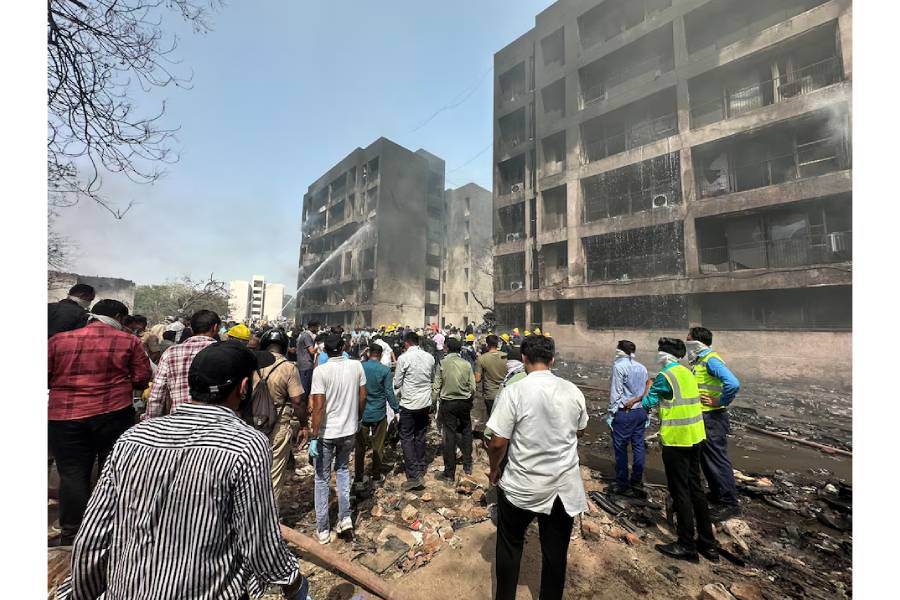 People gather near the site where an Air India plane crashed in Ahmedabad, India, June 12, 2025.