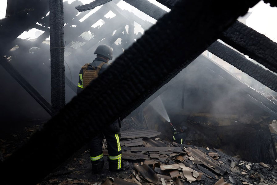 Firefighters work on a roof of an apartment building, damaged during Russian drone and missile strikes, amid Russia's attack on Ukraine, in Kyiv, Ukraine July 10, 2025.