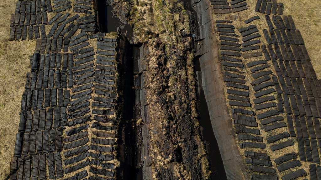 A drone view shows turf from Derryrush bog left out to dry after being harvested from the blanket bog, in Derryrush, Ireland, Apr 22, 2024. Ireland's bogs were formed over thousands of years as decaying plants formed a thick layer of peat in wetland areas. REUTERS/Clodagh Kilcoyne/File Photo