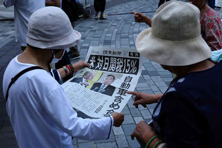 People react as they read a special edition of Yomiuri Shimbun newspaper reporting the tariff deal agreement between US and Japan, in Tokyo, Japan on July 23, 2025 — Reuters photo