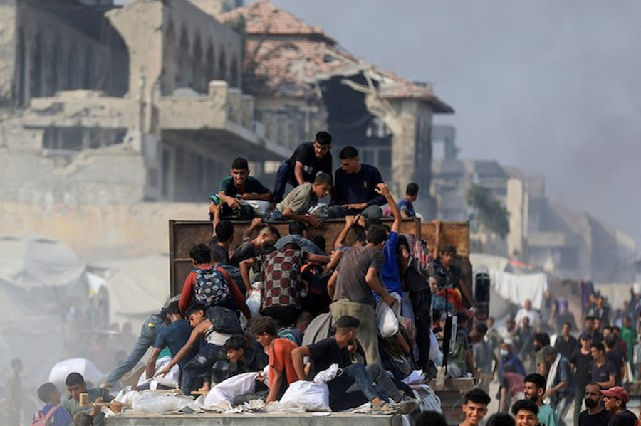 Palestinians ride on a truck as they collect aid supplies that entered Gaza through Israel, in Beit Lahia, in the northern Gaza Strip August 10, 2025.