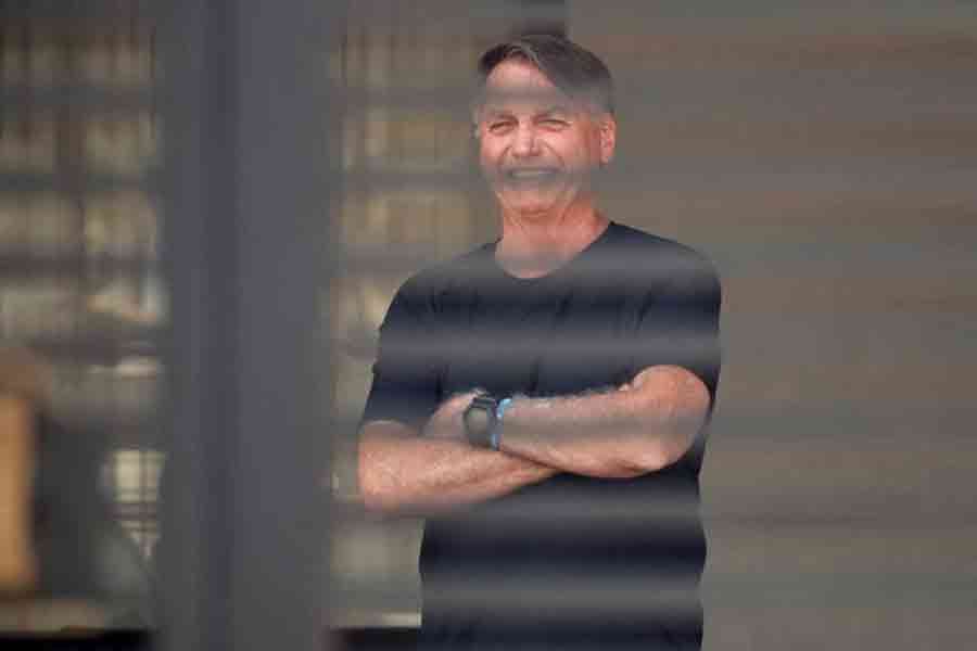 Brazil's former President Jair Bolsonaro stands at his home while under house arrest, ordered by Supreme Court Justice Alexandre de Moraes, as he awaits trial over an alleged plot to overturn the 2022 election, in Brasília, Brazil, Aug 14, 2025.