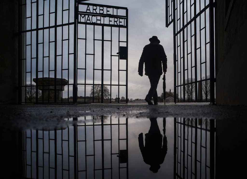 A man walks through the gate of the Sachsenhausen Nazi death camp with the phrase 'Arbeit macht frei' (work sets you free) at the International Holocaust Remembrance Day, in Oranienburg, about 30 kilometres, (18 miles) north of Berlin, Germany, Jan. 27, 2019. (AP Photo/Markus Schreiber, File)