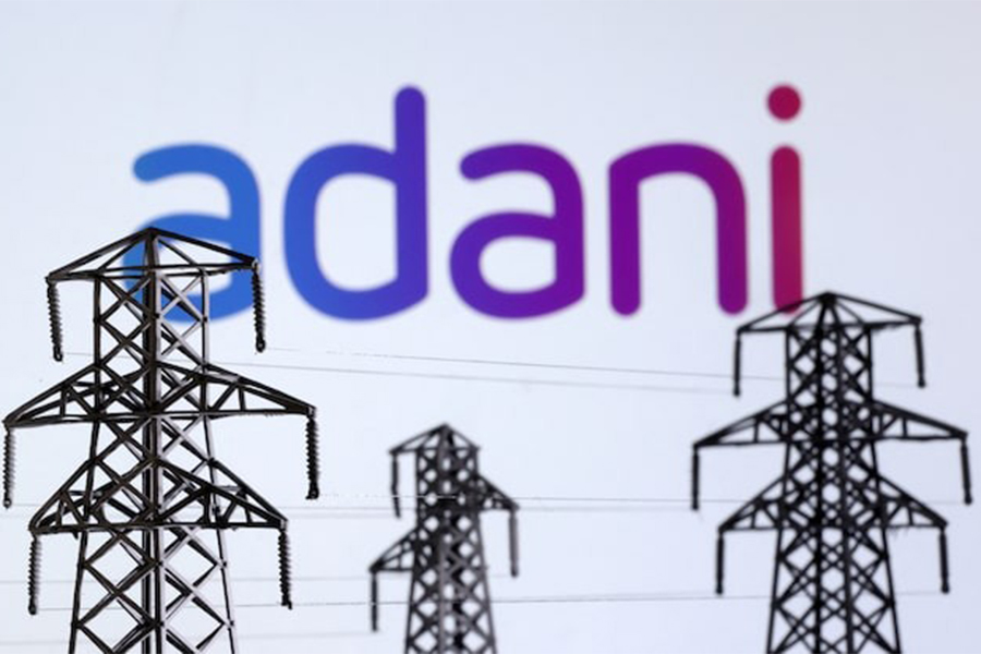 Electric power transmission pylon miniatures and Adani logo are seen in this illustration taken on December 9, 2022 — Reuters/File