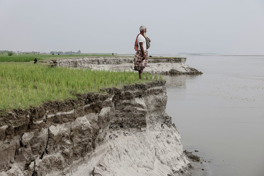 Kosim Uddin, 50, looks toward the site of his vanished home as he poses for a picture on an island in the Brahmaputra River, where he recently relocated due to erosion, in Kurigram, Bangladesh on October 29, 2025 — Reuters photo