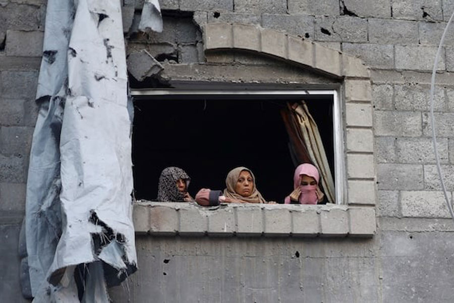 Palestinian women look out of a window near the site of Saturday's Israeli strike in the Central Gaza Strip, November 23, 2025.