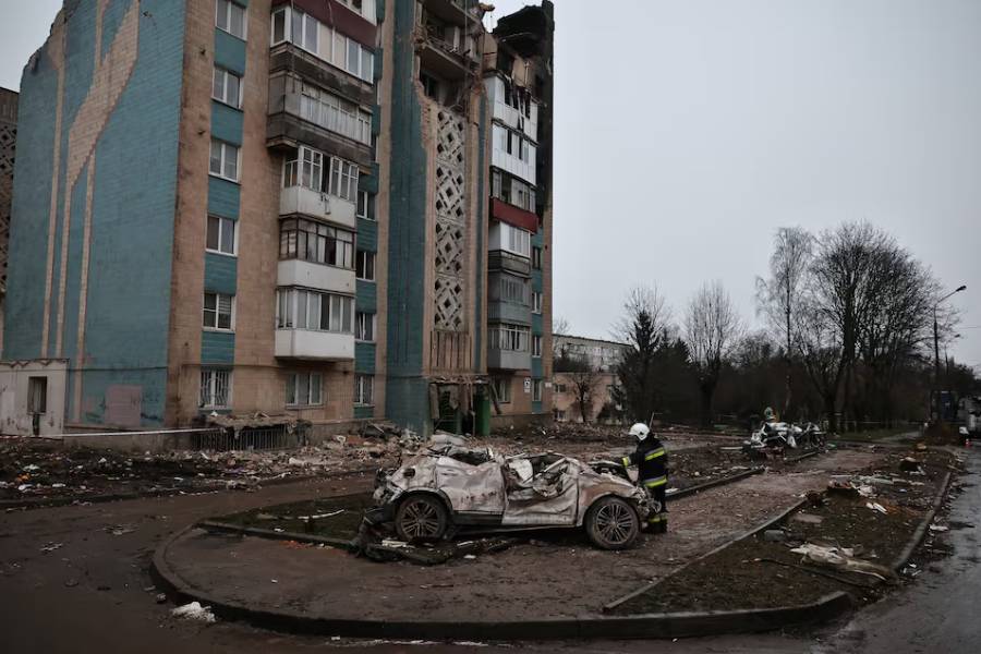 A firefighter looks at a car that was destroyed during a deadly Russian missile strike on an apartment building, amid Russia's attack on Ukraine, in Ternopil, Ukraine, November 21, 2025.