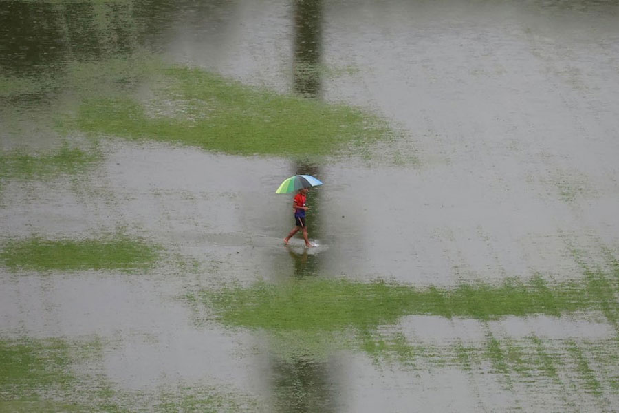 A man walks through floodwater as rain pours in Kuala Lumpur, Malaysia, November 24, 2025.
