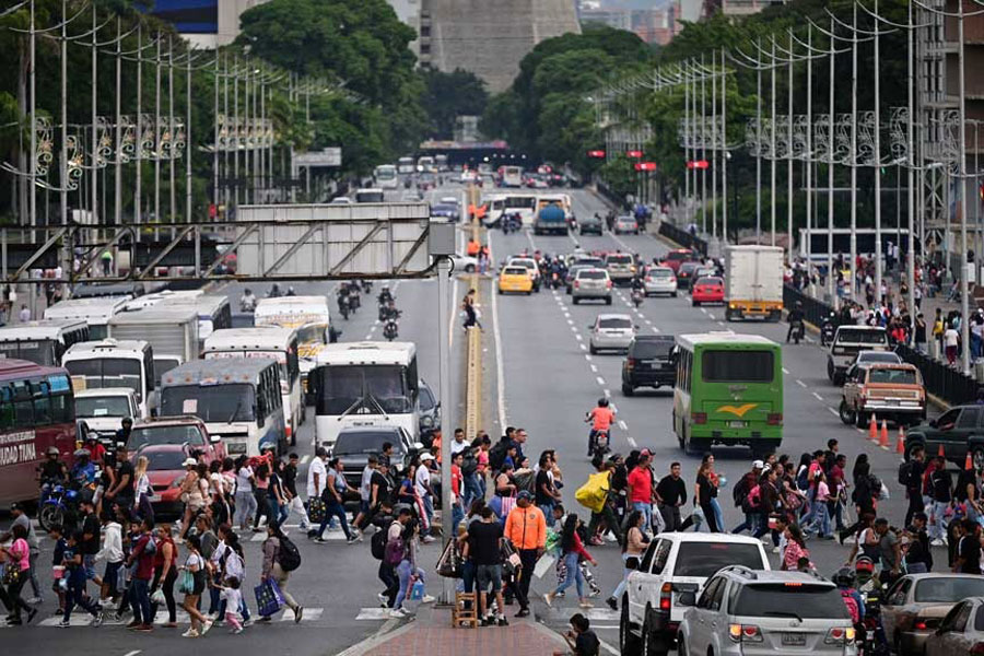 Pedestrians cross an avenue, after US President Donald Trump said on Saturday that the airspace above and around Venezuela would be completely closed, amid rising tensions between the Trump administration and the government of Venezuelan President Nicolas Maduro, in Caracas, Venezuela, Nov 29, 2025.