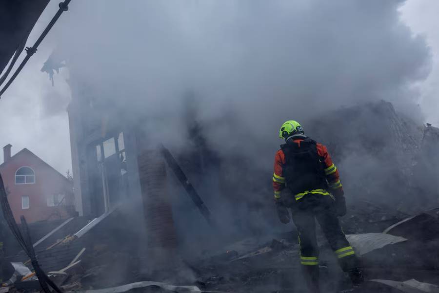 A firefighter stands at the site of a private home that went up in flames after it was hit by a Russian drone during a night of attacks on Kyiv, amid Russia's attack on Ukraine, November 29, 2025.