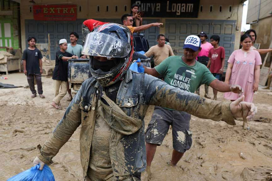 Survivors collect relief supplies in an area affected by deadly flash floods following heavy rains in Kuala Simpang, Aceh Tamiang regency, Aceh province, Indonesia, Dec 5, 2025. REUTERS/Ajeng Dinar Ulfiana