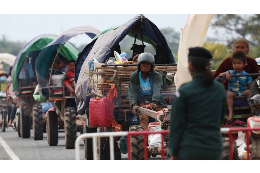 A police officer guides people to a refugee camp as they are evacuate amid deadly clashes between Thailand and Cambodia along a disputed border area, in Chong Kal, Oddar Meanchey Province, Cambodia, Dec 10, 2025.