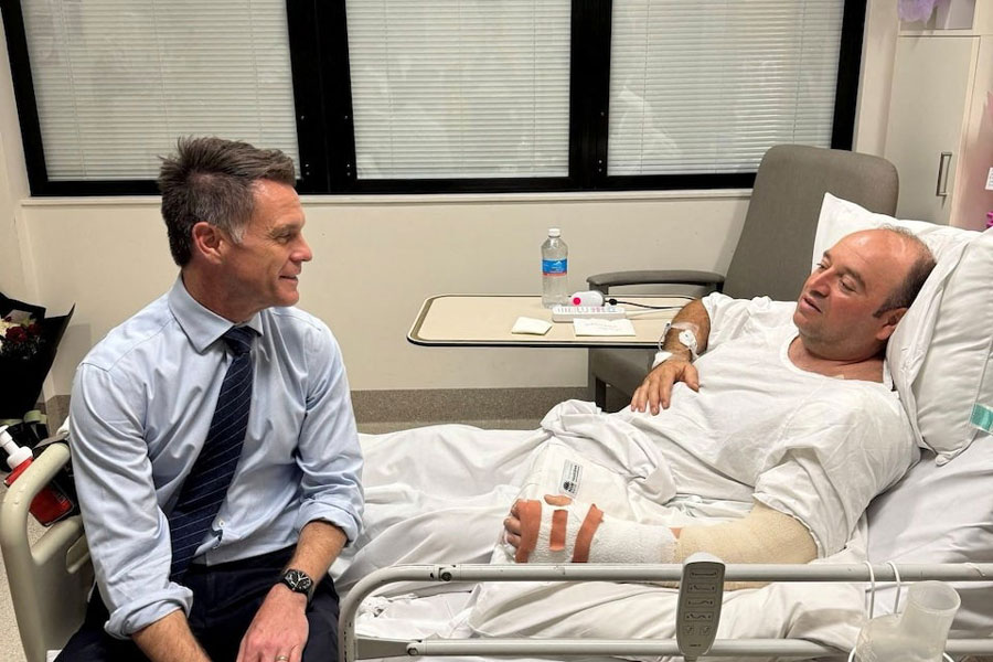 New South Wales Premier Chris Minns visits Ahmed al Ahmed, who was identified on social media as the bystander who hid behind parked cars and seized a rifle from one of the gunmen during the deadly shooting at Bondi Beach on Sunday, at a hospital in Sydney, Australia, December 15, 2025, in this picture obtained from social media.