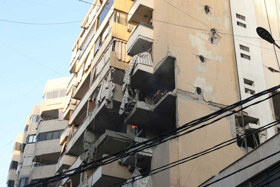 People inspect a damaged building, after Israeli military said on Sunday that it struck a militant from the Lebanese Iran-aligned Hezbollah group, in Beirut's southern suburbs, Lebanon Nov 23, 2025.