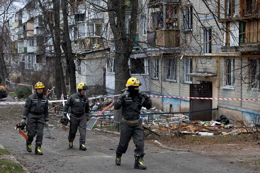 Emergency responders leave the site of an apartment building that was hit by a Russian drone, amid Russia's attack on Ukraine, in Kyiv, Ukraine Dec 23, 2025.