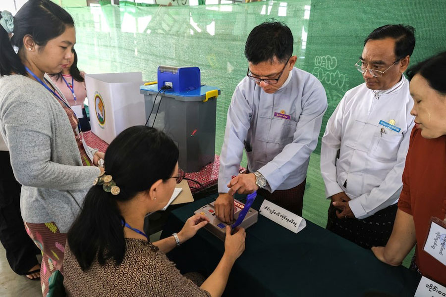 Election Commission officials prepare at a polling station inside a school ahead of a general election, in Thingangyun Township, Yangon, Myanmar, December 27, 2025.