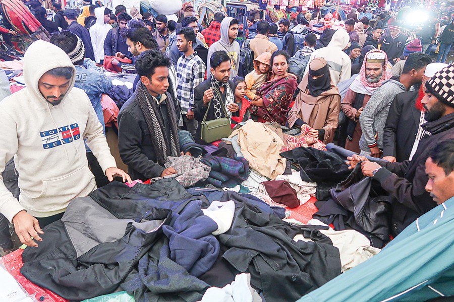 Warm clothes are now much in demand as a mild cold wave has gripped the country. In the photograph taken in the Gulistan area on Monday, people buy winter clothes of their choice — FE photo