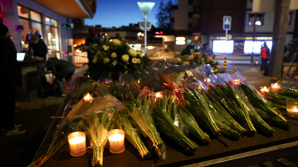 Flowers and candles are left near the "Le Constellation" bar, after a fire and explosion during a New Year’s Eve party where several people died and others were injured, according to Swiss police, in the upscale ski resort of Crans-Montana in southwestern Switzerland, Jan 1, 2026. REUTERS