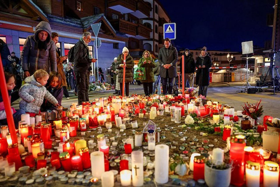 People gather by a makeshift memorial near the "Le Constellation" bar, after a fire and explosion during a New Year's Eve party in which people died and others were injured, in the upscale ski resort of Crans-Montana in southwestern Switzerland, January 2, 2026.