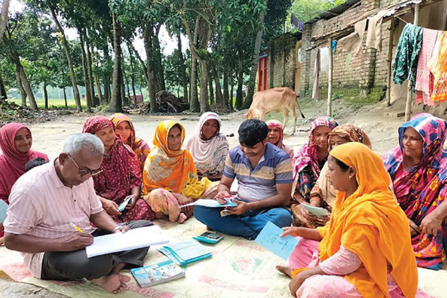 Staffs updating status of the microcredit borrowers of a MFI in Bangladesh —Collected Photo