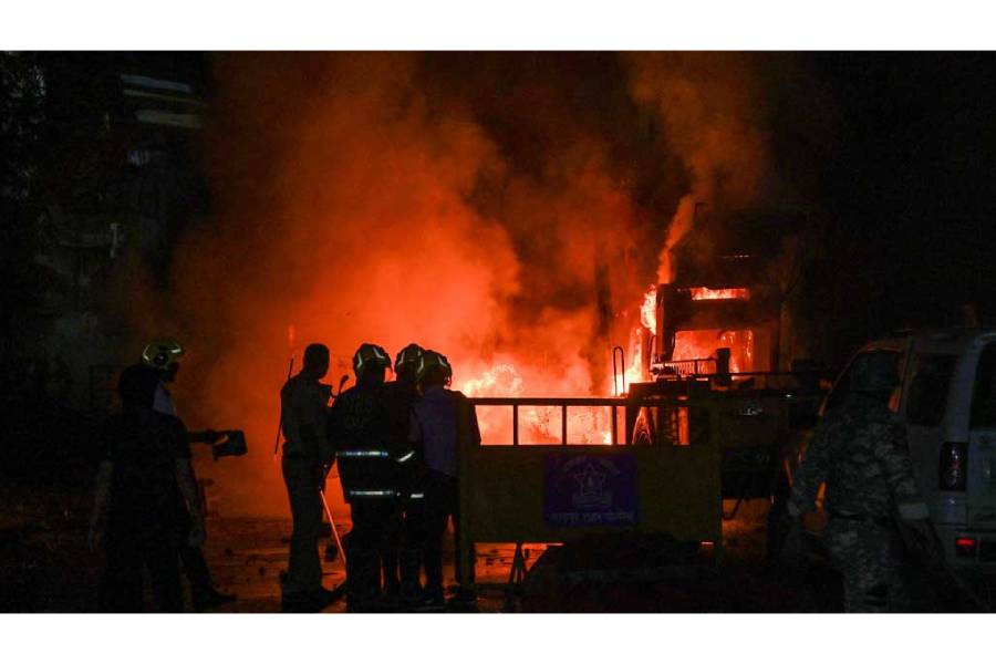 Members of police stand as vehicles burn after clashes erupted due to demands over removal of the tomb of Mughal emperor Aurangzeb, in Nagpur, India, Mar 17, 2025.