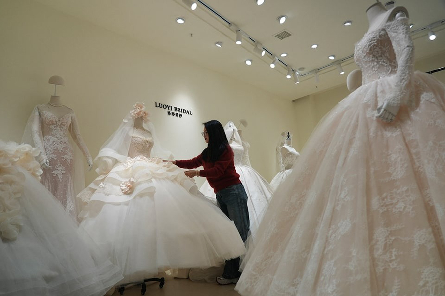 Chen Juan, co-owner of wedding dress shop Luoyi Bridal, adjusts a gown on display at the shop in Huqiu Bridal City in Suzhou, Jiangsu province, China on January 16, 2026 — Reuters photo