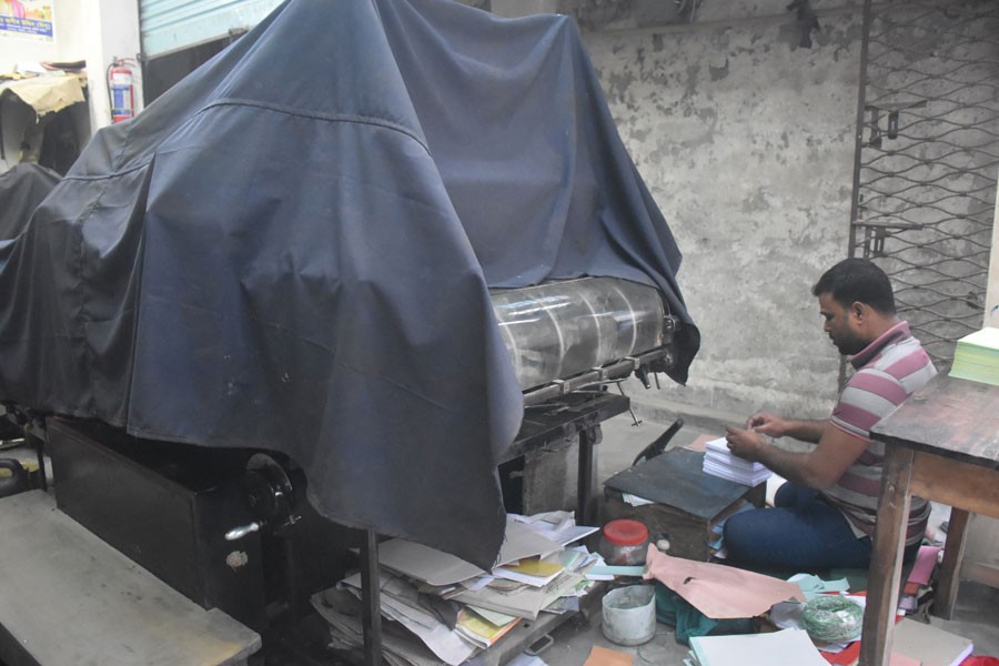 Photo shows a worker at a printing press in Manikganj town sits idle as there are no orders for election posters, banners, or stickers. — FE Photo
