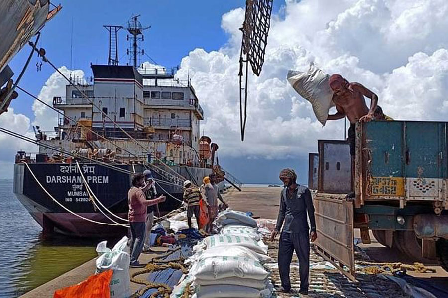 Labourers unload rice bags from a supply truck at India's main rice port at Kakinada Anchorage in the southern state of Andhra Pradesh, India, Sept 2, 2021.