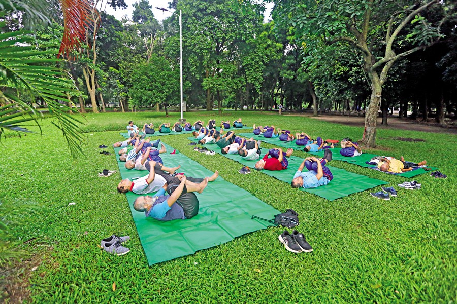 A group of morning walkers engages in exercise routines amid the tranquil ambience of Raman Park, nestled within the bustling city. —FE photo by KAZ Sumon
