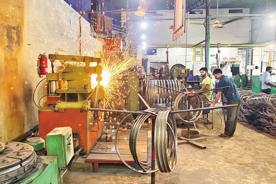 Workers making rims of bicycle tyres at a metal industrial unit at the BSCIC Industrial Estate of Jhumjhumpur in Jashore — FE file photo