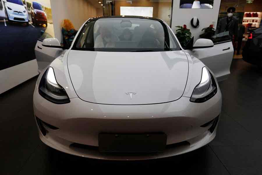 Visitors checking a Tesla Model 3 car at a showroom of the US electric vehicle (EV) maker in Beijing of China on February 4 this year –Reuters file photo