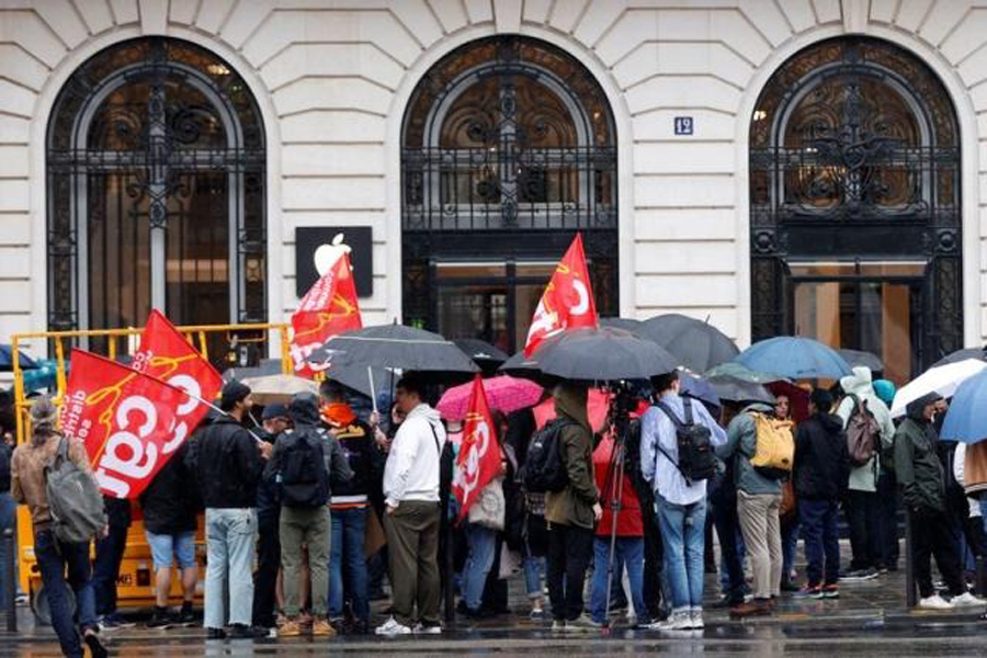 Apple France workers on strike holding CGT labour union flags gather in front of the Apple Store near Place de l'Opera during a protest to demand higher pay and better benefits on the day Apple launches its iPhone 15, in Paris, France, September 22, 2023.