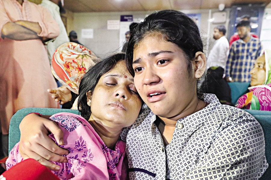 The daughter and the wife of Bhuban Chandra Shil, who succumbed to bullet wounds on Monday, burst into tears at Popular Hospital in Dhaka where he had been undergoing treatment. — FE Photo