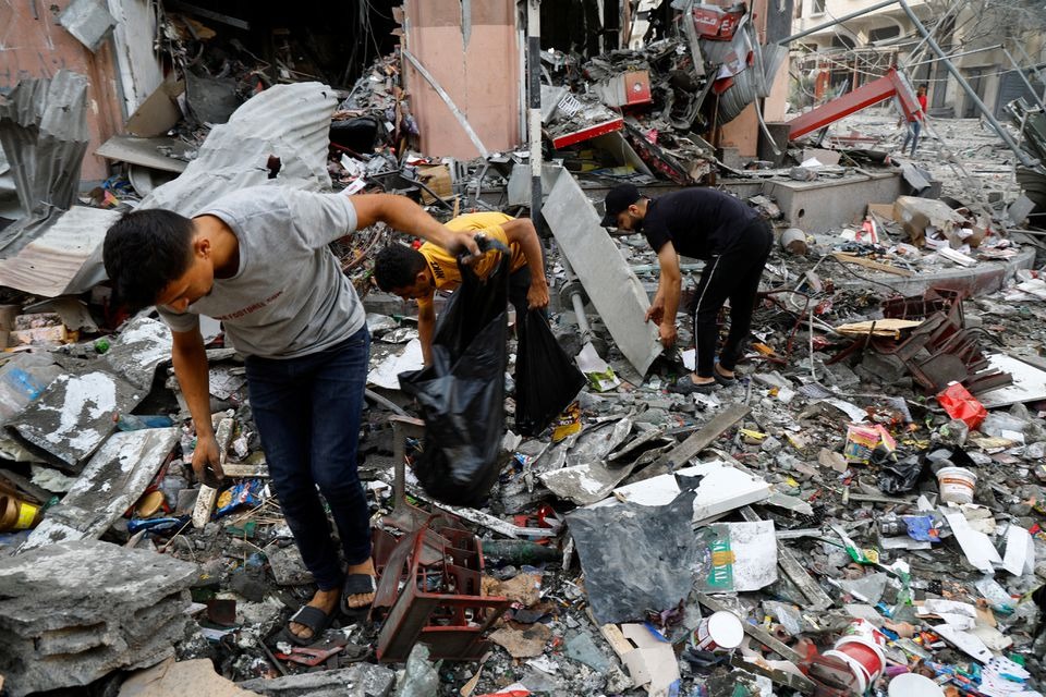 Palestinians look through debris in the aftermath of Israeli strikes, in Gaza City on October 11, 2023 — Reuters photo
