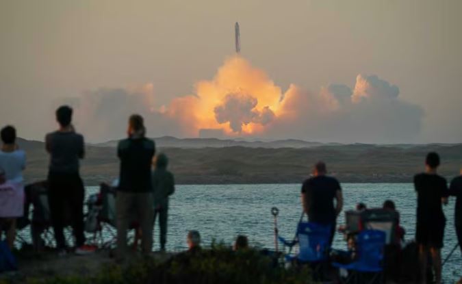 People watch as SpaceX's next-generation Starship spacecraft atop its powerful Super Heavy rocket lifts off from the company's Boca Chica launchpad on an uncrewed test flight, as seen from South Padre Island, near Brownsville, Texas, US November 18, 2023. REUTERS