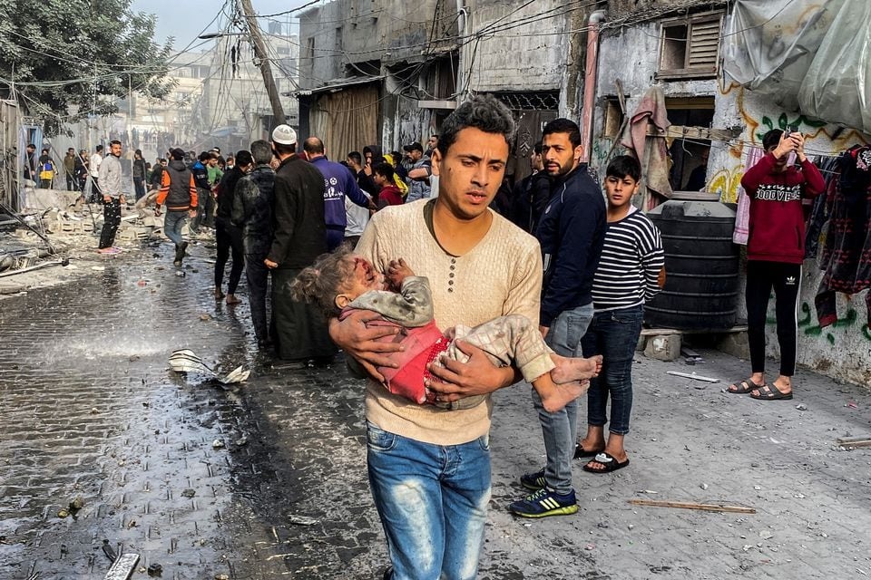 A Palestinian carries a casualty following an Israeli strike on a house, after a temporary truce between Hamas and Israel expired, in Rafah, in the southern Gaza Strip on December 1, 2023 — Reuters photo