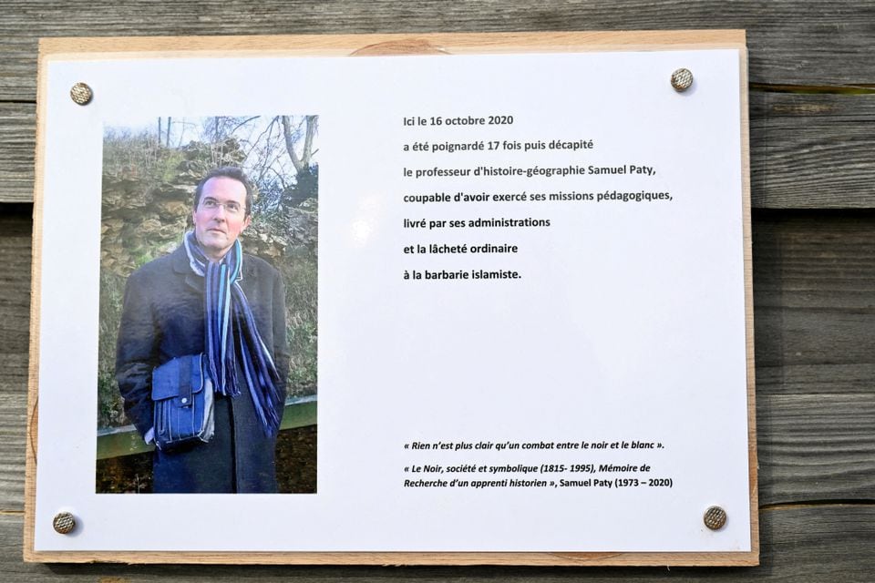 A photograph taken on October 16, 2023 shows a commemorative plaque for slain teacher Samuel Paty (portrait) near the Bois d'Aulne school in Conflans-Sainte-Honorine, outside Paris. BERTRAND GUAY/Pool via REUTERS/File Photo