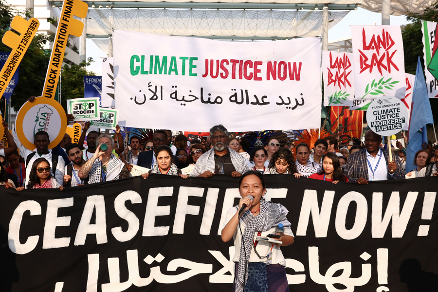 A woman holds a microphone as people protest for climate justice and a cease fire in Gaza, amid the ongoing conflict between Israel and the Palestinian Islamist group Hamas, during the United Nations Climate Change Conference COP28, in Dubai, United Arab Emirates on December 9, 2023— Reuters Photo