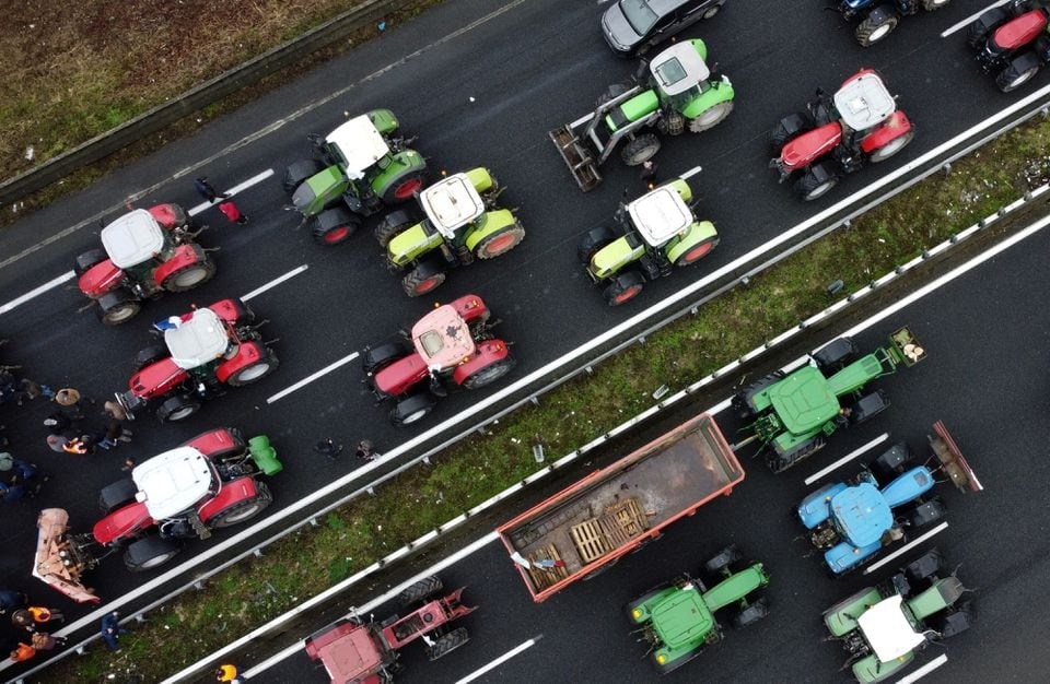 French farmers use their tractors to block the A1 highway near a highway toll station as they protest over price pressures, taxes and green regulation, grievances shared by farmers across Europe, in Chamant, near Paris, France, January 26, 2024.