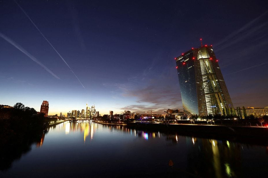 The sun sets behind the skyline and the European Central Bank (ECB, R) during a warm autumn evening in Frankfurt, Germany, October 1, 2023.