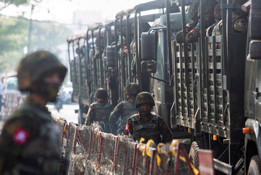 Soldiers stand next to military vehicles as people gather to protest against the military coup, in Yangon, Myanmar on February 15, 2021 — Reuters/File