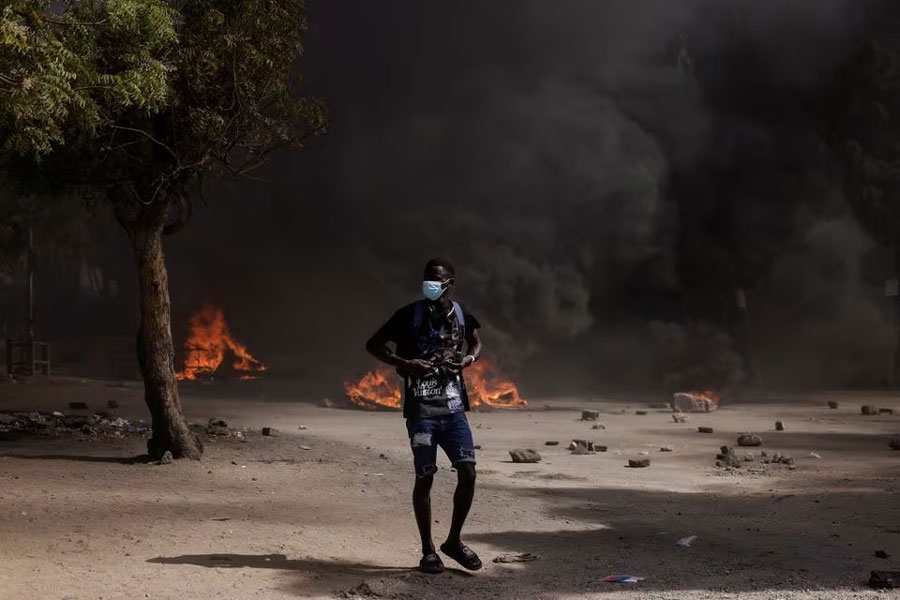 A Senegalese demonstrator stands watch during clashes with riot police as they protest against the postponement of the Feb. 25 presidential election, in Dakar, Senegal February 9, 2024.
