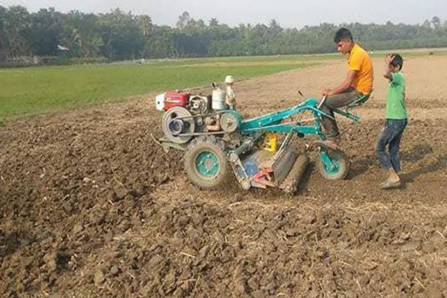 A farmer busy tilling a groundnut field with a tractor at Char Nagdah in Jamuna Char area of Bera upazila of Pabna district — FE Photo