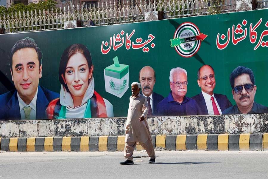 A man walking next to a billboard displaying photos of politician Bilawal Bhutto and his sister Asifa Bhutto, a day after general elections in Karachi, Pakistan on Friday –Reuters file photo