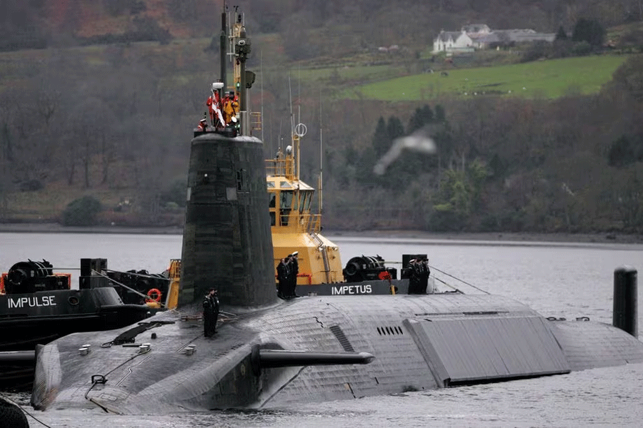 Crew from HMS Vengeance, a British Royal Navy Vanguard class Trident Ballistic Missile Submarine, stand on their vessel as they return along the Clyde river to the Faslane naval base near Glasgow, Scotland December 4, 2006.