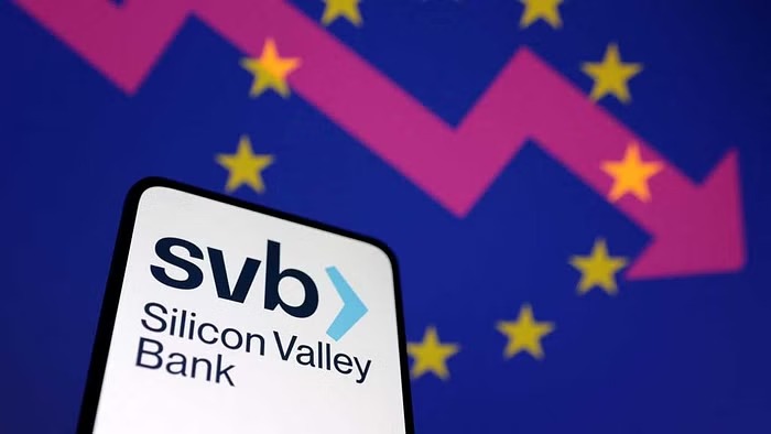 SVB (Silicon Valley Bank) logo, decreasing stock graph and EU flag are seen in this illustration taken Mar 12, 2023.