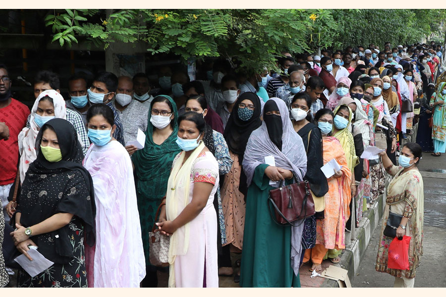 People are waiting outside a vaccination centre in Dhaka to receive the first dose of the Covid-19 jab in 2021