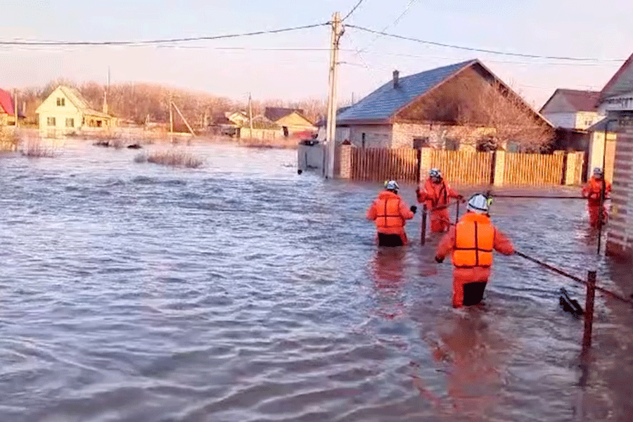 Rescuers make their way on a flooded residential area in the city of Orsk, Russia, April 6, 2024, in this still image taken from video.